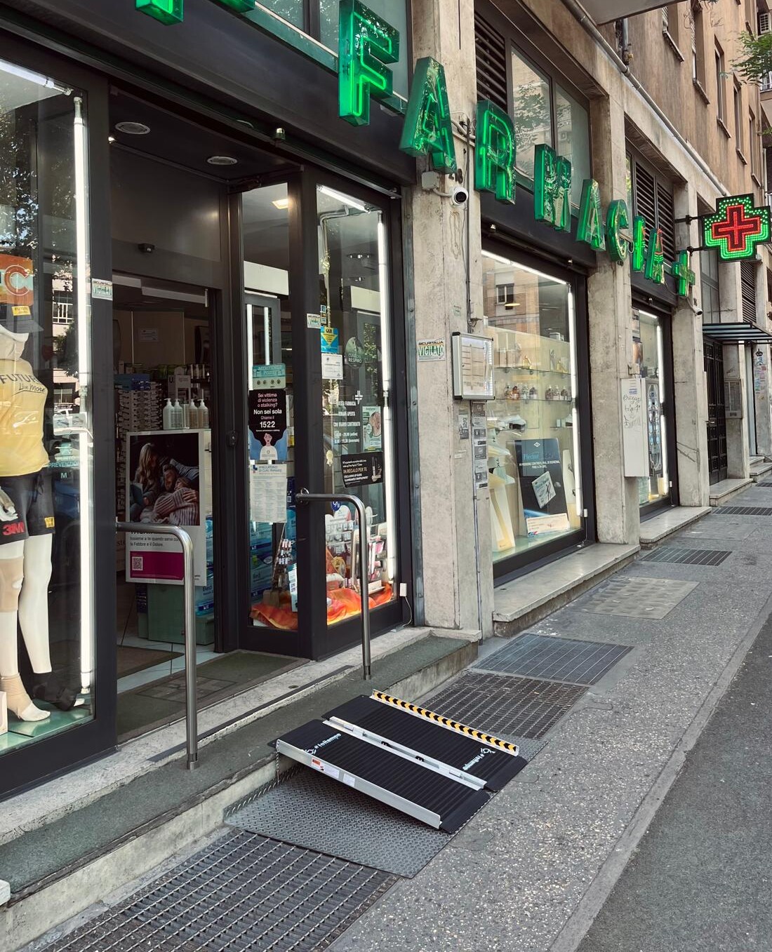 Ingresso di una farmacia che presenta uno scalino che però non è una barriera architettonica perché è presente una rampa mobile